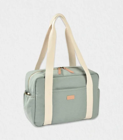 Baby diaper bag Paris Puffy quilted blue‑sage organic‑cotton exterior clipped to stroller beside Burj Khalifa, showing roomy 16 L interior, insulated sleeve and fold‑flat changing mat—ideal Dubai baby gift shipped worldwide for newborn and toddler essentials, unisex style for modern parents.